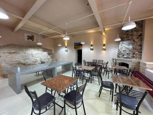 TufailahTafileh-Sila'a Heritage Village的一间带桌椅和石墙的餐厅