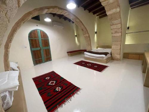 TufailahTafileh-Sila'a Heritage Village的一间设有两张床的客房,地板上设有两块地毯。