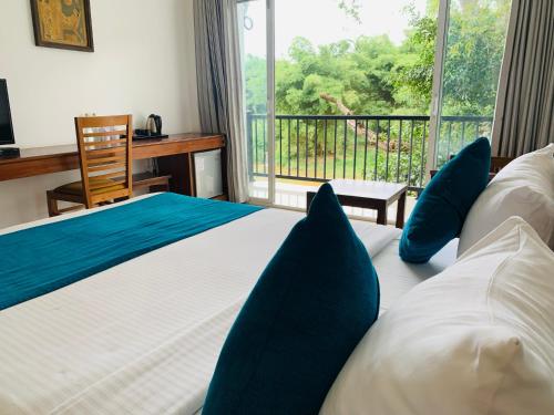 康提格达瑞酒店的一间卧室配有一张带蓝色枕头的床和一扇窗户。