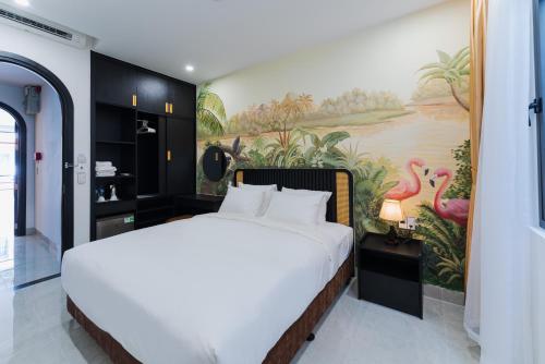 芽庄Q Boutique Hotel的卧室配有一张大床,墙上挂有绘画作品