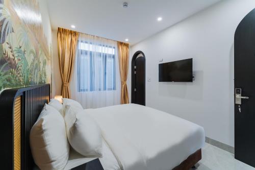 芽庄Q Boutique Hotel的卧室配有白色的床和电视