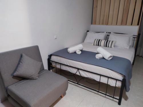 卡尔帕索斯Captain's Mermaid Houses, Karpathos的一间小卧室,配有一张床和一把椅子