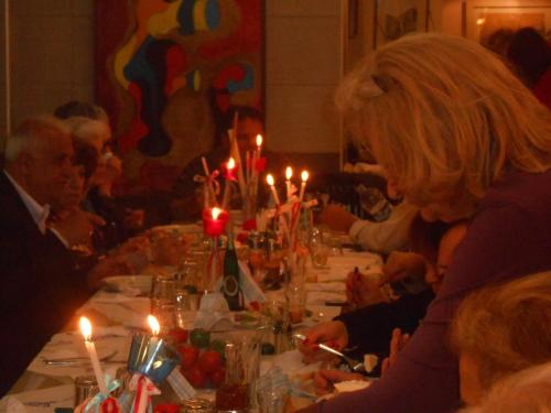 尼基亚娜Hotel Pegasos的一群人坐在一张长桌边,拿着蜡烛
