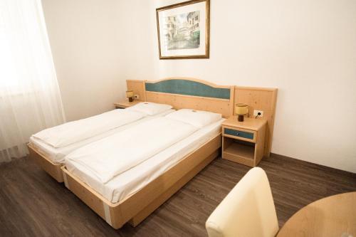 埃尼亚珀斯特宾馆的一间小卧室,配有一张床和一张桌子