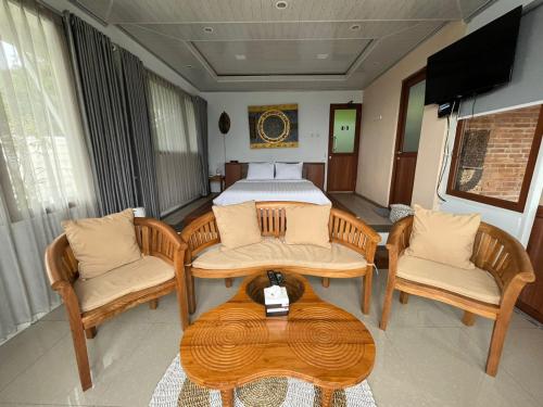 CampakaDe Pointé Resort & Resto的一间卧室配有一张床、两把椅子和一张桌子