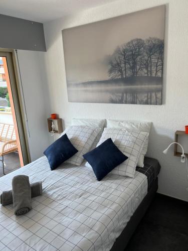 滨海卡瓦莱尔« Le Andrea »的卧室内的白色床和蓝色枕头