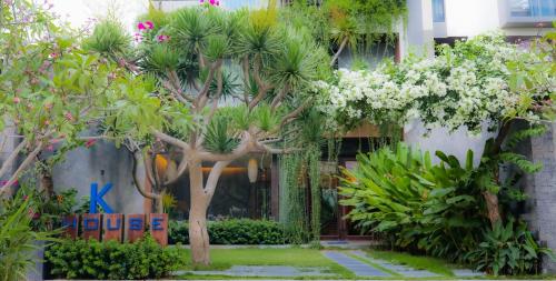 岘港K-House vs Apartment的一座花园,在一座建筑前种有树木和花卉