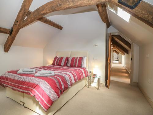 伯福德Malt Barn的一间卧室配有一张带红白毯子的床