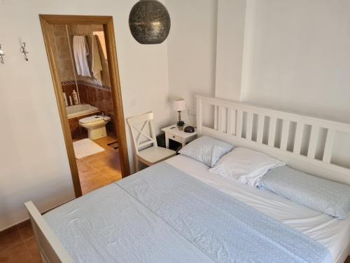 韦尔瓦Pinares de Lepe的一间带白色床的卧室和一间浴室