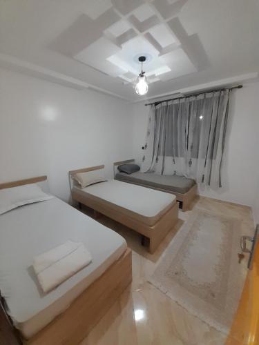 拜尔坎دار ضيافة的白色的客房设有两张床和窗户。