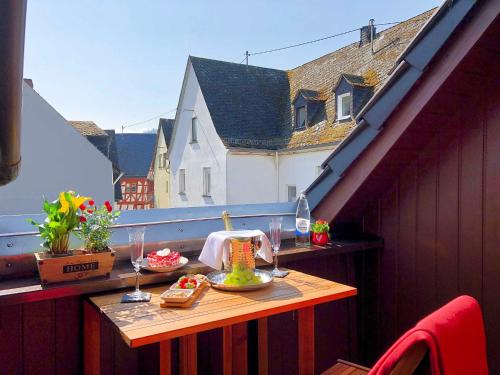 埃迪格尔-埃莱尔Ferienhaus-Am-Alten-Stadttor的阳台上配有带食物和酒杯的桌子