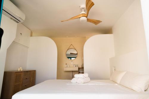 阿桂拉斯La Casa Turquesa的卧室配有白色的床和吊扇