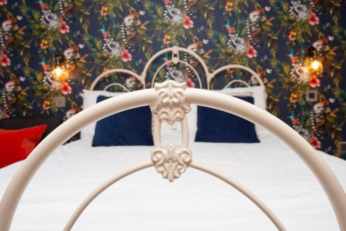 卡迪夫higgihaus #5 Room 6 Monday - Friday的白色的床、蓝色枕头和花卉墙