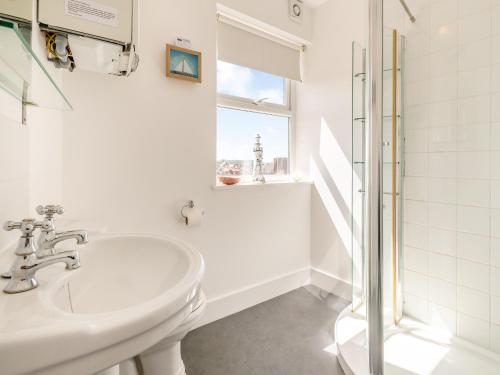 谢林汉姆海草乡村别墅的白色的浴室设有水槽和淋浴。