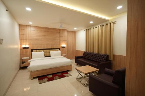 戈勒克布尔Hotel Pradeep Star Inn的酒店客房,配有床和沙发