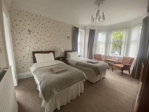 利文-法夫Lomond Guest House的酒店客房,配有两张床和椅子