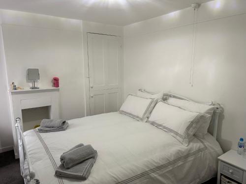 克劳奇河畔伯纳姆14 crouch road的白色卧室配有带2条毛巾的床
