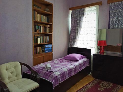 泰拉维GuestHouse LILIA &Wine Celler的卧室配有床、椅子和窗户。