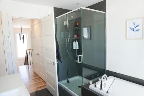 魁北克市Le Citadin - Maison neuve moderne & ensoleillée的一间带玻璃淋浴和浴缸的浴室