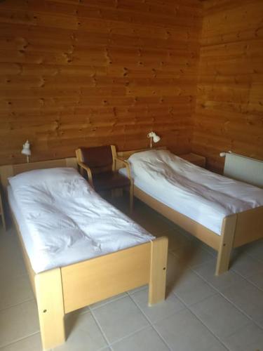 诺德堡Lyst dobbelt værelse med egen indgang og bad的木墙客房的两张床