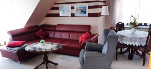 维斯马Ferienhaus in der Hansestadt mit Blick auf Ostsee的客厅配有红色的沙发和桌子