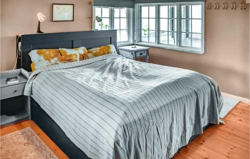 Nice Home In Heggedal With Wifi And 4 Bedrooms的一间卧室配有一张带条纹床罩的大床