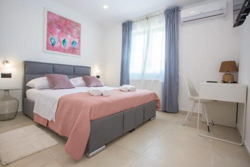 卡斯特里尔Villa Silvano & Nadija的一间卧室配有一张带粉色毯子的大床