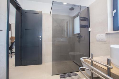 卡斯特里尔Villa Silvano & Nadija的带淋浴的浴室和玻璃门