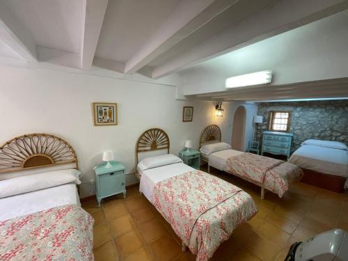 PenáguilaCasa Rural El Molí - Penáguila的一间卧室设有两张床和石墙