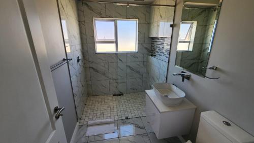 兰格班One Bedroom Unit with Kitchenette in Langebaan Country Estate - Solar Power的带淋浴、卫生间和盥洗盆的浴室