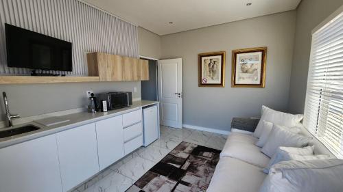 兰格班One Bedroom Unit with Kitchenette in Langebaan Country Estate - Solar Power的带沙发的客厅和厨房