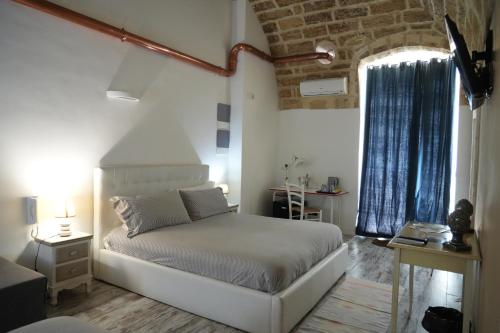 焦亚德尔科莱B&B Il Grifone的卧室配有白色的床和窗户。