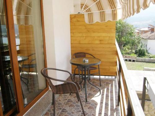 奥赫里德Villa Scandik Ohrid的阳台的天井配有桌椅