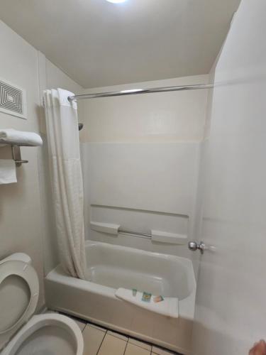 Moodybudgetel Inn & Suites的带淋浴和卫生间的浴室