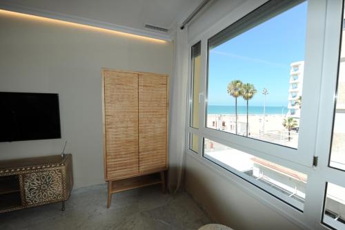 加的斯Apartamento reformado con vistas al mar的客厅设有大窗户,享有海滩美景