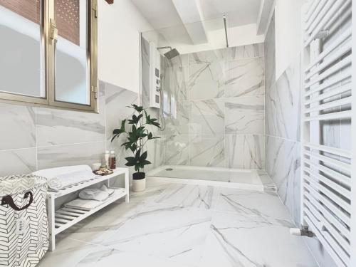MesolaLa Villetta nel Delta的浴室配有白色大理石墙壁和浴缸。