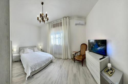 MesolaLa Villetta nel Delta的一间白色卧室,配有床和电视