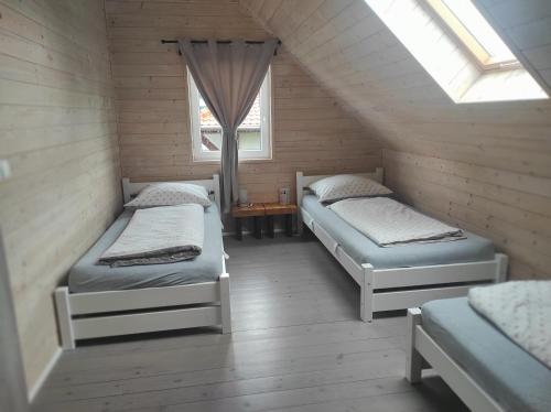 格里兹鲍Domki na Polnej的阁楼间 - 带两张床和窗户
