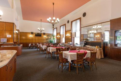 比尔森比尔森斯洛文酒店的用餐室配有桌椅和吊灯。