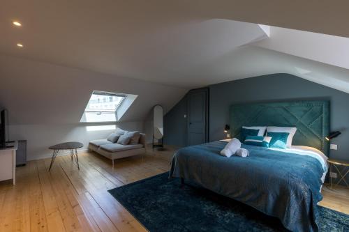 勒芒Villa Misano的一间卧室配有蓝色的床和沙发