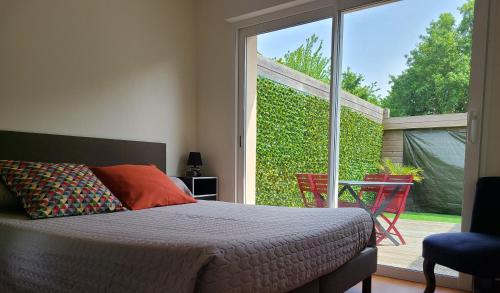 圣布里厄Meublé classé 3 étoiles的一间卧室设有一张床和一个滑动玻璃门
