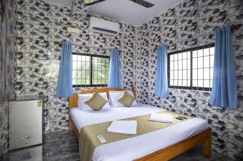 巴加Marcelo Holiday Home Goa的一间卧室配有2张蓝色窗帘
