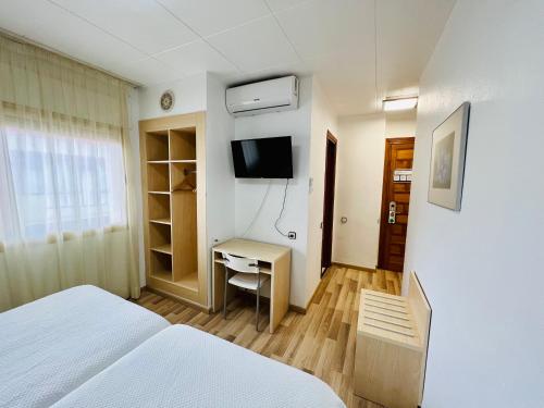 托尔托萨托尔托萨公园酒店的一间卧室配有一张床、一张书桌和一台电视