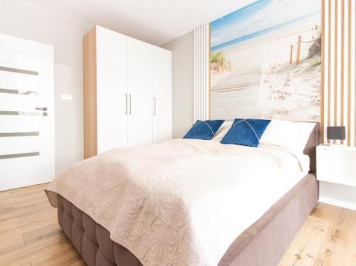 济夫努夫Alexis apartament Dziwnów的卧室配有带蓝色枕头的大型白色床