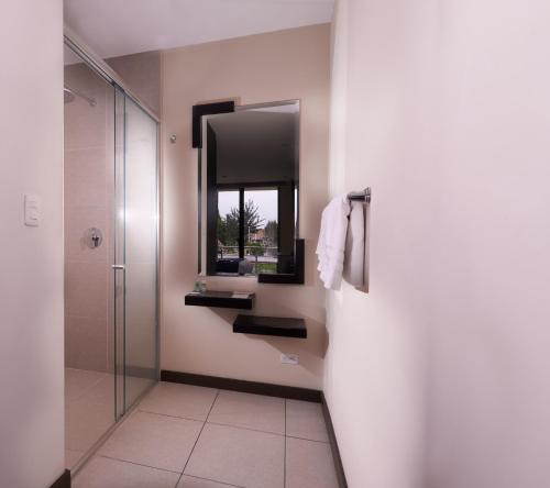 昆卡Venue Hotel的带淋浴、盥洗盆和镜子的浴室