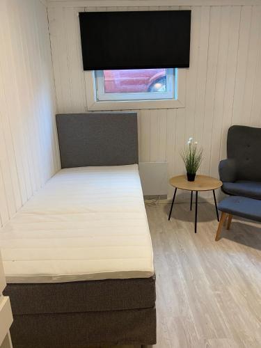 奥斯陆Hybel i gamle Oslo的卧室配有床、椅子和窗户。