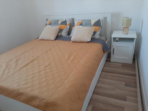 沃迪切Apartman-Kuzminski-Kraje14的一间卧室配有一张带橙色和蓝色枕头的大床