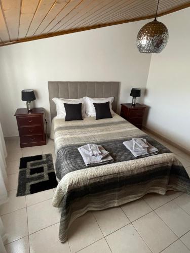 圣特奥托纽Alojamento Amor de Mãe的一间卧室配有一张带2个床头柜的大床