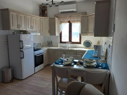 卡尔帕索斯Annissa Appartment的厨房配有桌子和白色冰箱。