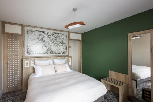 卡马雷Résidence Bellevue的卧室配有白色的床和绿色的墙壁